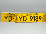 COLECONISMO - Par de placas automotiva em alumínio, sendo traseira e dianteira - Amarelas - RJ - Duque de Caxias - YD 9189. Med. 13x40 cm.