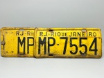 COLECONISMO - Par de placas automotiva em ferro, sendo traseira e dianteira - Amarelas - RJ - Rio de Janeiro - MP 7554. Med. 16x35 cm e 16x40 cm.