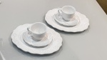 Par de xícaras em cerâmica branca, acompanhadas de pires e delicado pratinho oval. Peças de linhas clássicas e elegantes, com acabamento suave e atemporal, ideais tanto para uso quanto para compor uma mesa posta refinada. Conjunto charmoso que valoriza qualquer coleção ou ocasião especial.