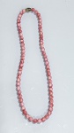 COLAR DE CONTAS ESFÉRICAS EM TONALIDADE CORALColar composto por contas esféricas uniformes em tonalidade coral (rosado alaranjado), apresentando variações naturais de cor com áreas mais intensas e outras mais suaves, conferindo aspecto marmorizado à peça. Superfície polida, com brilho suave e acabamento homogêneo.Montagem por encadeamento contínuo, formando composição clássica e elegante.PERÍODO: contemporâneo ou vintageTÉCNICA: polimento e montagemFECHO: não visível (não identificado nas imagens)ESTADO DE CONSERVAÇÃO: bom estado geral, com leves sinais de uso compatíveis, sem quebras aparentes nas contas.OBSERVAÇÕES: material com características compatíveis com coral ou material similar, destacando-se pelas variações naturais de tonalidade e pelo acabamento polido.