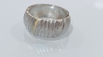 ANEL EM PRATA DE LEI COM FILETE DOURADOAnel em prata de lei, de aro largo, apresentando superfície externa com acabamento texturizado em sulcos verticais irregulares, valorizado por filete central com banho dourado, criando elegante contraste bicolor.Peça de design contemporâneo, com linhas orgânicas e presença marcante, adequada ao uso cotidiano ou composição com outras joias.PERÍODO: contemporâneoMATERIAL: prata de lei com detalhe banhado a ouroTÉCNICA: ourivesaria com acabamento texturizadoESTADO DE CONSERVAÇÃO: bom estado geral