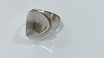ANEL EM PRATA COM DESIGN ORGÂNICOAnel confeccionado em prata, sem marca de teor aparente, apresentando aro com design contemporâneo e estrutura aberta, levemente ajustável.A peça se destaca pelo topo de formato irregular, com linhas suaves e acabamento que remete a formas orgânicas, conferindo aspecto moderno e artístico. Superfície com leve textura e áreas polidas, criando jogo sutil de luz e reflexo.Modelagem ampla na parte frontal, proporcionando presença visual marcante