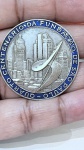 MEDALHA COMEMORATIVA EM PRATA DE LEI  QUARTO CENTENÁRIO DA FUNDAÇÃO DE SÃO PAULOMedalha comemorativa confeccionada em prata de lei, sem marca de teor aparente.Apresenta em seu anverso composição em relevo com representação da cidade de São Paulo, incluindo elementos arquitetônicos e escultura central estilizada. Borda circular esmaltada em tonalidade azul, com inscrição: QUARTO CENTENÁRIO DA FUNDAÇÃO DE SÃO PAULO.Acabamento com áreas polidas e foscas, evidenciando o relevo e os detalhes da peça. Formato circular, com boa definição de cunhagem.Peça de caráter histórico e colecionável, em bom estado geral de conservação.