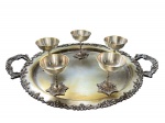 Bela e antiga bandeja em metal espessurado a prata, possui bordas e alças decoradas cinzeladas. Acompanha 5 tacinhas para sobremesa / drink em metal espessurado a prata com bases ricamente cinzeladas decoradas. Peças com marcas de uso e do tempo, ínfimas 