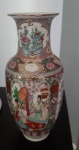 O jarro de porcelana chinesa possui uma forma alongada e é ricamente decorado com padrões detalhados de flores e cenas tradicionais chinesas. As cores predominantes são verde, rosa, vermelho, dourado e branco, e a ornamentação reflete a sofisticação e tradição artística da porcelana chinesa.- Altura: 37