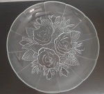 O prato de bolo em de vidro transparente  e fosco ,  possui um design decorativo com rosas e folhas gravadas no fundo. A borda do prato é suavemente ondulada,. As rosas no centro são detalhadas e bem definidas, proporcionando uma aparência sofisticada e refinada ao prato. Este tipo de prato é ideal para servir bolos e sobremesas, especialmente em ocasiões especiais, devido à sua estética delicada e charmosa. Diâmetro: 33 cm