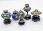 CLOISONNÉ - JAPÃO - Delicado e belo lote composto por cinco mini potiches. Executados em metal esmaltado de ótima fundição e adornados por ricas tonalidades vibrantes. Em perfeito estado de conservação. Quatro apoiadas sobre bases de madeira e uma não, maior mede 7,5 cm de altura aproximadamente com base.