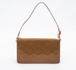 Louis Vuitton - Paris - Elegante bolsa Lexinton Bronze confeccionada em verniz na cor bronze com estampa com monograma da marca em baixo relevo, modelo retangular pequeno, possui alça única de mão em couro, com mosquetão em uma das extremidades, compartimento único, fecho por zíper com ferragens douradas, altura 12 cm, largura 20,5 cm, profundidade 4 cm, alça de ombro 18 cm (alça com manchas de guardado, parte interna com manchas de mofado), acompanha manual e dust bag. Bolsa usada, verniz e metais em bom estado de conservação.