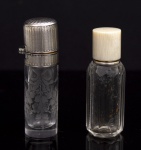 Colecionismo - Lote constando de dois antigos e delicados perfumeiros europeus cerca de 1900, sendo um com tampa em prata de lei cinzelado em guilhochê, parte interna com banho de ouro e pequena rolha interna, bojo em cristal lavrado com laços de fitas e guirlanda de flores med. 6x1,2 cm (tampa com pequeno amassado em uma lateral) e um perfumeiro com tampa em marfim com parte interna em prata e bojo lapidado e facetado med. 5,5x1,9 cm (falta a rolha de vidro interna).