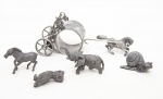 Lote constando de cinco antigas esculturas em estanho representando animais e carruagem para porta guardanapos sendo um elefante - med. 4x7x2 cm, uma coruja - med. 4x2 cm, um caramujo - med. 2x4x2 cm, um cavalo - med. 4x5x1,5 cm (falta o rabo) e carruagem com cavalo - med. 6x12x5 cm ( uma haste lateral solta) - Todas as peças com desgastes do tempo, no estado)