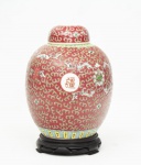 Antigo potiche em porcelana Chinesa policromado e esmaltado, decorado com arabescos e flores e medalhões laterais com ideogramas sobre fundo bordô, assinado com selo vermelho na base med. 27x13 cm (potiche), acompanha base em madeira entalhada med. 4x15 cm de diâmetro.