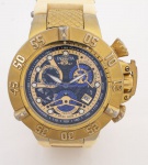 Invicta - Subaqua - Chronograph - Relógio de pulso masculino com caixa em aço dourado, mostrador dourado, azul e preto - Day Date - Movimento Quartz. Pulseira em borracha original, caixa med. 5x5,7 cm. Relógio usado (vidro com desgastes na borda, caixa com pequenos desgastes e pulseira falta acabamento em um dos dos lados). Máquina sem garantia de funcionamento.