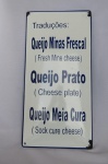 COLECIONISMO - PLACA ESMALTADA com a tradução em Inglês literalmente ao pé da letra (Frases não compreendidas pelos povos da língua Inglesa) - Uma das frases: QUEIJO MINAS FRESCAL (FRESCH MINE CHEESE). Com desgastes nas laterais em razão do tempo. Mede aprox. 40 x 20 centímetros. Escritas em Baixo Relevo.