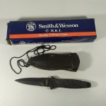 CUTELARIA - FACA SMITH & WESSON H.R.T. - TÁTICA E SOBREVIVÊNCIA, com Bainha e Corrente para o pescoço. Sem uso e na Caixa original. Fabricada na China (primeira linha) sob licença da S&W. Caixa com detalhes