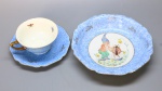 PORCELANA BAVARIA - Conjunto infantil em porcelana alemão, vitificada, delicadas flores policromadas e cena de gnomo com joaninha em reserva central.Composta de: xícara de chá, pires e bowl. Anos 30. Bicados e fios de cabelo.