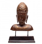 Arte Oriental - Belo busto de madeira finamente entalhado, com realces em dourado, representando "Buddha da Serenidade". Século XX. Med. 34 x 27 x 10 cm (Medidas busto); 47 x 31 x 13 cm (medidas totais). Marcas do tempo.  Acervo Particular Rio de Janeiro/RJ. Nota: O Buda da Serenidade, é uma representação simbólica bastante comum na arte oriental e em práticas de espiritualidade ligadas ao budismo, embora não exista uma figura histórica com esse nome específico. A expressão pode se referir a uma escultura, pintura ou imagem de Buda em estado meditativo e tranquilo  normalmente com os olhos semicerrados, o rosto sereno. Seu significado simbólico é : Paz interior: Transmite a ideia de equilíbrio emocional e mental; Meditação: Representa o estado profundo de concentração e desapego do mundo exterior; Compaixão e sabedoria: A serenidade do rosto de Buda simboliza uma mente desperta, mas em paz;   Proteção do ambiente: Muitas pessoas colocam esse tipo de imagem em casa ou no jardim como símbolo de harmonia e proteção energética.