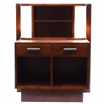 Laubisch-Hirth - Pequeno móvel de apoio de madeira nobre, estilo art déco, com iluminação nas laterais. Presença do selo de fabricação. Med. 90 x 75 x 42 cm. Marcas de uso. A parte elétrica requer revisão apesar de estar funcionando. Acervo Particular Rio de Janeiro/RJ. Nota: Laubisch-Hirth (Rio de Janeiro, RJ, 1914), foi a mais importante fábrica de móveis do Rio de Janeiro entre 1920 e 1950, conhecida por sua produção de móveis no estilo Art Déco. Fundada pelos alemães Carlos Laubisch e Georg Hirth, a fábrica se destacou por introduzir conceitos de luxo e sofisticação europeia ao mercado brasileiro. Durante seu período de maior influência, a Laubisch-Hirth produziu móveis notáveis que decoram muitas residências e instituições de prestígio, incluindo o casarão que hoje abriga o Fórum da Cultura da Universidade Federal de Juiz de Fora (UFJF). O estilo "pé palito" disseminado pela marca, na época, tornou-se uma característica emblemática do mobiliário retrô até os dias de hoje. Nota de Transporte: Este móvel não poderá ser enviado pelos correios.