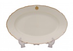 Duque D'Aosta -  01 travessa oval do Serviço de porcelana brasonada da Casa Real da Itália - Duque D'Aosta - Marca de manufatura  francesa "Le Rosey".  Porcelana de esmaltagem branca, apresenta elegantes frisos e brasão realçados a ouro. Sendo: 01 travessa oval, Med. 5 x 40 x 27 cm.  Marcas de uso. Desgastes . Pequenas faltas. Acervo Particular Rio de Janeiro/RJ.