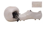 Günther Uecker (1930, Alemanha) & Y Fongi (1936 -2012, Alemanha), "Uecker-Schuh mit Ball". Escultura de cerâmica vidrada e pregos. Assinado na Base em relevo. Década de 70. Sem tiragem e edição aparentes. Med. 14 x 35 x 17 cm (ME). Marcas do tempo. falta 1 pregos. Coleção Particular Rio de Janeiro/RJ. Nota: A obra Uecker-Schuh mit Ball é uma escultura criada em 1972 pela colaboração entre os artistas alemães Günther Uecker e Y. Fongi. Esta peça consiste em um sapato de futebol de gesso adornado com pregos, acompanhado por uma bola, também de gesso, igualmente cravada com pregos. A escultura mede aproximadamente 14 x 35 x 17 cm e apresenta carimbo em relevo UECKER & FONGI. A Uecker-Schuh mit Ball reflete a experimentação artística da época, combinando elementos do cotidiano com materiais industriais para desafiar as convenções artísticas tradicionais. Esta obra foi leiloada em diversas ocasiões, destacando-se como um exemplo significativo da colaboração entre Uecker e Fongi. NOTA BIOGRÁFICA UECKER :  Günther Uecker (nascido em 1930, Alemanha) é um renomado artista contemporâneo, amplamente conhecido por suas esculturas e relevos em que utiliza pregos como principal elemento. Ele foi membro do grupo ZERO, um movimento artístico dos anos 1950 e 1960 que buscava renovar a arte explorando luz, movimento e estrutura. Principais características de sua obra.  Uso de pregos martelados em madeira e outros materiais para criar superfícies dinâmicas e táteis. Exploração de luz e sombra, criando efeitos ópticos e de movimento. Interesse em arte cinética e instalações interativas. Temas ligados à destruição, reconstrução e espiritualidade. Destaques de sua carreira. Em 1966, participou da Documenta 4 em Kassel. Criou cenários para óperas e balés, expandindo sua arte para outras mídias. Suas obras estão em museus como o MoMA (Nova York), Tate Modern (Londres) e Centre Pompidou (Paris). Ainda ativo, Uecker continua a explorar novas possibilidades dentro de sua estética única.NOTA BIOGRÁFICA FONGI :  Y. Fongi, nascido Werner Gartung em 2 de janeiro de 1936 em Vechelde, Alemanha, e falecido em 13 de maio de 2012 em Zschachenmühle, foi um artista alemão multifacetado associado ao realismo crítico, pop art, arte conceitual e ao movimento Fluxus. Autodidata, iniciou sua carreira artística em 1963, criando pinturas com óleo e ketchup, cultivando culturas de fungos sobre elas. Seus trabalhos incluem objetos feitos de materiais diversos, como sapatos usados e malas antigas, além de desenhos e ações performáticas.Em 1969, Fongi integrou o coletivo artístico Zehn-Neun, que buscava democratizar a arte tornando-a mais acessível ao público. Em 1972, desenvolveu o conceito da Kontakteria, um café destinado a discussões e interações sociais, que deveria ter sido parte da Documenta 5 em Kassel, mas não foi realizado devido a divergências com a organização.No mesmo período, Fongi colaborou com Günther Uecker, outro artista alemão renomado, conhecido por suas esculturas e instalações que frequentemente incorporam pregos. Juntos, criaram obras que refletem a experimentação e inovação características da época.Em 1975, Fongi afastou-se do circuito artístico convencional, tornando-se discípulo de Osho e adotando o nome Siddhartha. Fundou várias comunidades Osho na Alemanha e, posteriormente, em Zschachenmühle, onde passou seus últimos anos trabalhando em suas memórias.Após quase quatro décadas afastado, Fongi foi redescoberto em 2009 pela Galerie Westerheide, que exibiu suas esculturas, gravuras e impressões, reintroduzindo sua obra ao público. Fonte :IA.