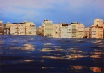Gisela Gleizer ( Rio de Janeiro, 1963), " ". Fotografia. Impressão Fine Art, jato de tinta pigmento sobre  papel  Hahnemühle. Da série "Rio de janeiro". Ano: 2023. Assinada, numerada e com selo holográfico no verso, número 444511. Tiragem 1/4 (primeira impressão). Med. 110 x 80 cm (formato);  100 x 70 cm (mancha); 83,5 x 113,5 cm (ME). Nota de impressão: Impresso em  papel Hahnemühle Studio, 210 gsm, produzido usando pigmentada UltraChrome K3 da Epson, no laboratório fotográfico Fine Arte Estúdio Lupa , certificado pela Hahnemühle. Acompanha Certificado. Acervo Particular da artista.  Nota Biográfica: Carioquíssima, Musicoterapeuta por profissão com formação no Conservatório Brasileiro de Música, iniciou o seu processo criativo enquanto fotógrafa em 2016, após passar por um dificílimo câncer de mama, que lhe trouxe um novo olhar para a vida e tudo que a envolve. A vida se tornou urgente, esse negócio de amanhã ficou muito incerto... Foi quando o tal projeto de nadar no mar às 6 da matina finalmente aconteceu, e com ele, um olhar totalmente novo. Carioca, acostumada com a beleza do Rio, lugar mais fotografado do planeta, nunca havia tirado uma foto da cidade. Milhares de fotógrafos fazem isso todos os dias.  De cima, de baixo, de asa delta, de barco, de bicicleta, da montanha, do Pão de Açúcar, do cristo, com sol, com chuva, arco íris e por aí vai. Nadar no mar, porém, revelou ângulos totalmente inusitados, literalmente de tirar o fôlego. Entre uma braçada e outra, no meio de cardumes e tartarugas, sol nascendo, ondas indo e vindo, nem sempre é fácil captar aquele momento mágico, pois em milésimos de segundos tudo muda, as correntes e as ondas não param. O mar não tem bordas, não dá pra armar o tripé ou pedir para esperar um pouquinho,  muito menos repetir. Ondas engolindo a cidade, encobrindo o Pão de Açúcar, tocando no céu, estourando na areia são imagens em movimento, de uma beleza indescritível  que revelam de outros ângulos, a famosa e fabulosa cidade maravilhosa e a certeza que o tempo não para. É o único click de um momento que nunca irá se repetir. Passar e vencer este delicado processo me deu este presente. O presente de estar presente integralmente a casa milésimo de segundo para não perder nenhum click. Foi através da fotografia que encontrei essa maneira linda de me relacionar com o aqui e agora e passar a minha mensagem poética da vida. Nota de transporte: O lote não poderá ser enviado pelos correios.