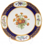 Porcelana - Belíssimo prato de coleção com borda em azul cobalto e ouro decorada ao gosto neo-clássico, com vegetais como Oeil de Crist e Ruellia Simplex em reservas e Oeillets d'Inde no centro da caldeira, todos identificados com legendas no avesso da peça - marca de manufatura - Sevres X no verso. Europa  - Cerca de 1900. Med. 3 x 23,5 cm (ME). Marcas e desgastes do tempo. Acervo Particular Rio de Janeiro/RJ.