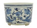 Arte Oriental - Cachepô de porcelana chinesa decorada com auspiciosos dragões  e a pérola em azul cobalto sobre fundo branco. Decoração "underglaze"- China - Século XIX/XX. Presença de  "double ring" e marcas na base. Med. 17 x 22 cm (ME). Marcas do tempo.  Trincado com antigo restauro." . Acervo Particular Rio de Janeiro/RJ. Nota: "Dois dragões e uma pérola" é uma imagem recorrente na mitologia e arte chinesa, frequentemente associada a pares de dragões lutando ou perseguindo uma pérola flamejante. Essa pérola, também conhecida como "perola da sabedoria" ou "perola do trovão", é um símbolo poderoso com múltiplos significados, incluindo energia espiritual, prosperidade, poder e imortalidade.