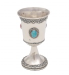 Elegante cálice de prata judaica, finamente adornado por trabalhos em filigrana e circundado por pedraria encastoada nas cores lilás , azul e rosa. Marca da prata de Israel. Marca do Prateiro não decifrado. Teor 925 milésimos. Med. 10,5 x 6 cm (medidas totais). Peso total: 60 gramas. Marcas do tempo e de uso. amassados na base. Acervo Particular Rio e Janeiro/RJ.
