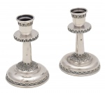 Elegante par de castiçais de prata judaica, de tamanho diminuto, finamente adornados por trabalhos em filigrana. Marca da prata de Israel. Marca do Prateiro não decifrado. Teor 925 milésimos. Med. 7 x 4,5 cm (medidas totais). Peso total: 41 gramas. Marcas do tempo e de uso. Amassados na base e em uma das hastes. Acervo Particular Rio e Janeiro/RJ.