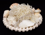 CENTRO DE MESA - Original centro de mesa circular, de tema "marinha", montado com conchas, corais brancos e figura de tubarão em cristal liso. Base com anelado em torsade. Apresenta pequenos defeitos. Med. ALt. 20,0 cm  Diâm. 35,0 cm.