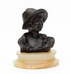 LINDA ESCULTURA em bronze patinado representando busto de menina camponesa com chapéu. Base circular de cor bege com borda em degrau. (Pequenos defeitos na base). Med. Alt.   17,0 cm.  (Com base) 12,0 cm (Sem base).