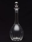 SAINT LOUIS - Garrafa piriforme em cristal liso, lapidada e ornada com suaves gomos até meia altura. Bojo abaulado com longo gargalo reto, rematado por borda revirada e tampa no formato de gota. Fundo com adorno estrelar. OBS: Marcas de uso e marcas do tempo. Med. Alt. 32,0 cm.