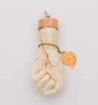 FIGA confeccionada em Osso, encimada por arremate em ourolavrado. Apresenta pulseira de argolas com pingenteem coração realçado por iniciais. OBS: (Apresenta defeito, rachadura)  Med. Compr. 5,0 cm.