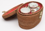 ORIGINAL CESTA DE PIQUINIQUE chinesa composta de conjunto  para chá. Constando de 2pequenos bowls e um bule em porcelana de formato cilíndrico com bico recurvoe alça em ferro. Apresentam decoração floral, realçada no bule por pássaros. Cesta oval trançada em junco e forrada em tecido vermelho. Frentecom largo fecho e tampa plana encimada por argolas. Marca desgastada sob a base. OBS: (Pequenos bicados na borda da tampa do bule) Med. Cesta Alt. 15,0 cm  Lar. 23,5 cm e Prof. 17,0 cm. Alt  Bule 12,0 cm  Alt. Bowls 5,5 cm. cada um.