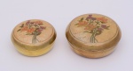 CAIXAS - Conjunto de 2 pequenas caixas circulares idênticas, porém de tamanhos diferentes, em metal dourado. Tampas ornamentadas por arranjos florais em esmaltes policromados. (Marcas do tempo). Med. Alt. 5,0 cm e Diâm. 11,0 cm.    Alt. 5,0 cm e Diâm. 9,0 cm.