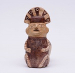 ESCULTURA - "Huaco silbador", em cerâmica moldada com dois vasos, realçado por pigmento marrom. Apresenta figura de xamã em relevo com adorno plumário na testa, acoplada a vaso com longo gargalo. Peça contemporânea no estilo da arte pré-colombiana. Deve o seu nome ao fato que, enchendo o vaso com água e movimentando os vasos alternadamente de cima para baixo, se obtém um assovio produzido pela passagem do líquido de um recipiente para o outro. Medidas : Alt. 22,0 cm  Compr. 17,0 cm