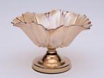 CENTRO DE MESA em vidro de cor bege dourado, moldado no formato de flor com longas pétalas reviradas na borda. Fundo lavrado com pistilo em relevo. Base lisa em metal dourado, de formato cônico, montada em degraus. OBS: Semi nôvo.  Medidas: Alt. 20,0 cm  Diâm. 30,0 cm.