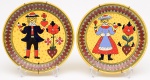 PAR DE PRATOS em cerâmica argentinapolicromada, decorados com casal em trajes típicos, apresentandopássaros e flores nas mãos sobre fundos amarelos. Bordas realçadaspor adornos geométricos. Versos marcados Ceramica BarilocheDecorado a Mano. Med. Diâm. 23,0 cm.