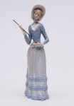 LLADRO - Estatueta em porcelana espanhola representando jovem professora com vareta apontadora na mão. Marca da manufatura sob a base. OBS: (Pequenos Restauros nas mãos). Med. Alt. 32,0 cm.
