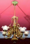 BELO LUSTRE em bronze e dourado para 5 luzes, construído com vaso bojudo moldado em arabescos e gomos. Colunata central reta, interrompida à meia altura por plateau ladeado por máscaras, sustentando braços recurvos com figuras de dragões alados e tulipas bojudas em vidro opalinado encimadas por bordas onduladas. Segmento superior com urna, ladeada por volutase hastes retas reunidas por coroa com rostos masculinos, encimada por coluna em torsade e canopla com folhagens dentadas. OBS: Possui pontos de oxidações. Med. Alt. 1,04 e Alt do corpo 0,62 m  Diâm. 0,70 m  ATENÇÃO:  RETIRADA DO LOTE NA PRAIA DO FLAMENGO, SOMENTE COM AGENDAMENTO PRÉVIO  E COM CUSTOS DE RESPONSABILIDADES EXCLUSIVAS DO ARREMATANTE.