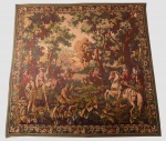 TAPEÇARIA feita a máquina representando uma cena de caça da época de Henrique IV, a cavalo com figuras da nobreza, servidores e cães no meio de floresta com edificações ao fundo. Borda com adornos florais e vegetais. Med. 2,10 m X 2,13 m.