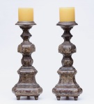 PAR DE ANTIGOS TOCHEIROS retos em madeira patinada, construídos com segmentos de balaústre, carreteis e anelados. Bobeches reviradas e bases almofadadas apoiadas em pés curtos e retos. Início do século XX.  Med. Alt. 70 cm