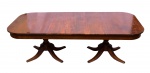 ANTIGA MESA DE JANTAR em madeira nobre, maciça, estilo inglês, com tampo retangular e quinas arqueadas. Par de colunas laterais de formato balaústre, torneadas e ornadas por folhagens e anelados, apoiadas em segmento cilíndrico ladeado por pernas recurvas esculpidas com motivos vegetais. Marcas de uso e do tempo. Med. Alt. 0,70 m.  Compr. 2,30 m  Larg. 1,14 m.