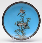 CLOISONNÉ - Antigo prato chinês em metal revestido e ornado por esmaltes cloisonnés sobre fundo azul. Apresenta grous pousados sobre bambus e árvores. Borda realçada por pequenas reservas geométricas. Obs: Possui  pequeno restauro. Verso com adornos espiralados. Med. Diâm. 30,0 cm.