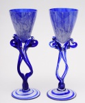 JOSEPHINA KROSNO (Polônia) -  Duas belas taças para vinho em vidro artístico azul e translúcido. Bojo azul fosqueado, haste em vidro tanslúcido e vazado, base redonda e plana com faixa azul em forma de espirais. Med. Alt. 22,5 cm Diâm. 7,0 cm