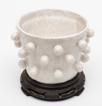 CACHEPOT para plantas em cerâmica continental, decoração com esferas em todo corpo. Possui marca de assinatura não identificada na base, Acompanha pedestal em madeira ebanizada. Med. Alt. 13,0 cm  Diâm. 16,0 cm.