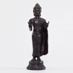 ESCULTURA EM BRONZE representando Imagem de Budha em pé, fazendo o gesto do Karana Mudra, afastando demônios e energias negativas. Camboja, final do Império Khmer, séc. XIV-XV. Med. 16,5 x 5,5 x 5 cm.