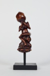 CABO DE "Kriss, adaga ritual da Indonésia, esculpido em madeira com resquícios de policromia, representando divindade ancestral. Nota-se o rosto com forte influência da arte dos Maori da Nova Zelândia e dos povos da Polinésia. Ilha de Bali, séc. XVIII-XIX. Base em madeira. Med. (sem a base) 13 x 5 x 4,5 cm