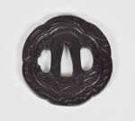 TSUBA - Raro e antigo Tsuba em ferro forjado, formato circular, ornamentada e lavrada com folhagens e nuvens. Período EDO ( 1603 - 1867 ). Medidas: Diâmetro - 7,0 cm. Tsuba é um disco de ferro utilizado em espadas japonesas com a finalidade de proteger as mãos.