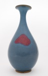 VASO piriforme em porcelana chinesa, decorado por coberta azul realçada por mancha em tons de vermelho roxeado. Bojo abaulado encimado por gargalo em corneta e borda revirada. Séc. XVIII. Med. 27,0 cm  Larg. 12,0 cm.
