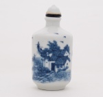 SNUFF BOTLE cilíndrica, em porcelana decorada em azul, representando cena de pesca com cormorões e casa. Tampa com colar, cabochão em porcelana e colher. Séc. XIX. Med. 8,0 cm Larg. 4,0 cm